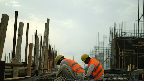 Construction workers in hard hats and safety vests on a job site