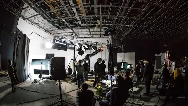 Film crew working on a soundstage with lighting equipment