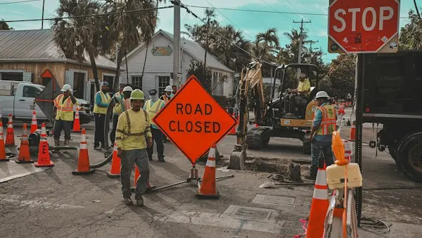 Road closed signs and construction workers on a city street